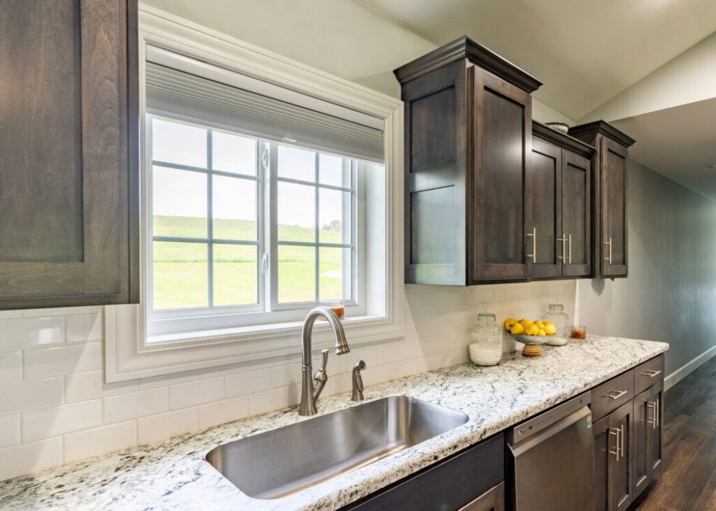 Modern kitchen with granite countertop and window.