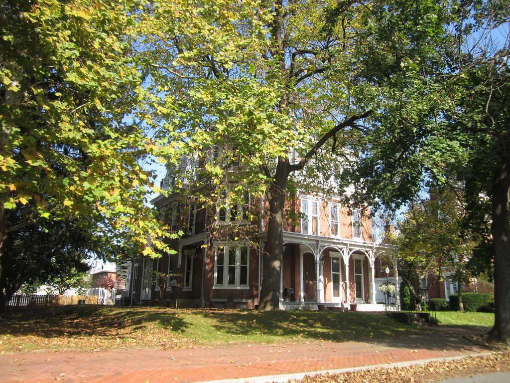 Historic brick house surrounded by trees.