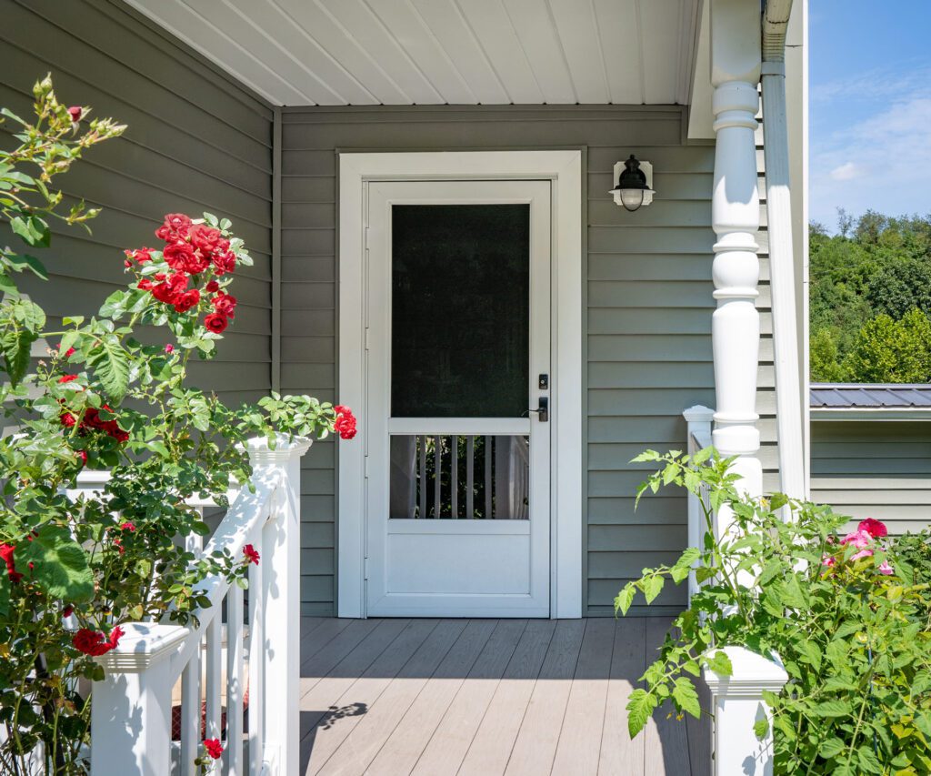 Front porch with roses and white door.