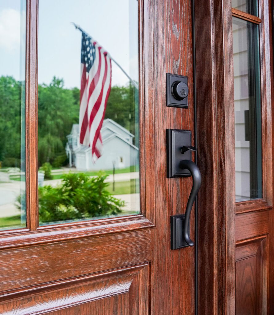 Wooden door with American flag reflection.